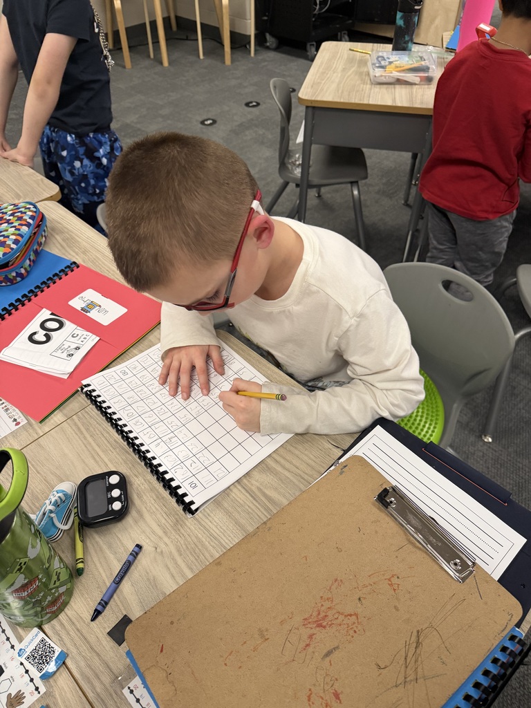 students practicing how to tie shoes in a classroom