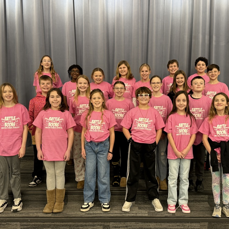 3 rows of battle of the books students in pink shirts smile for a team picture