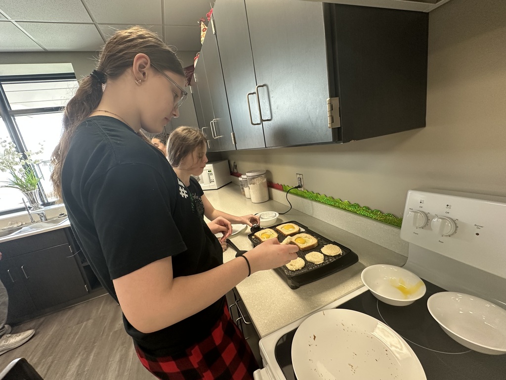 Photo of a female student making breakfast on a griddle.