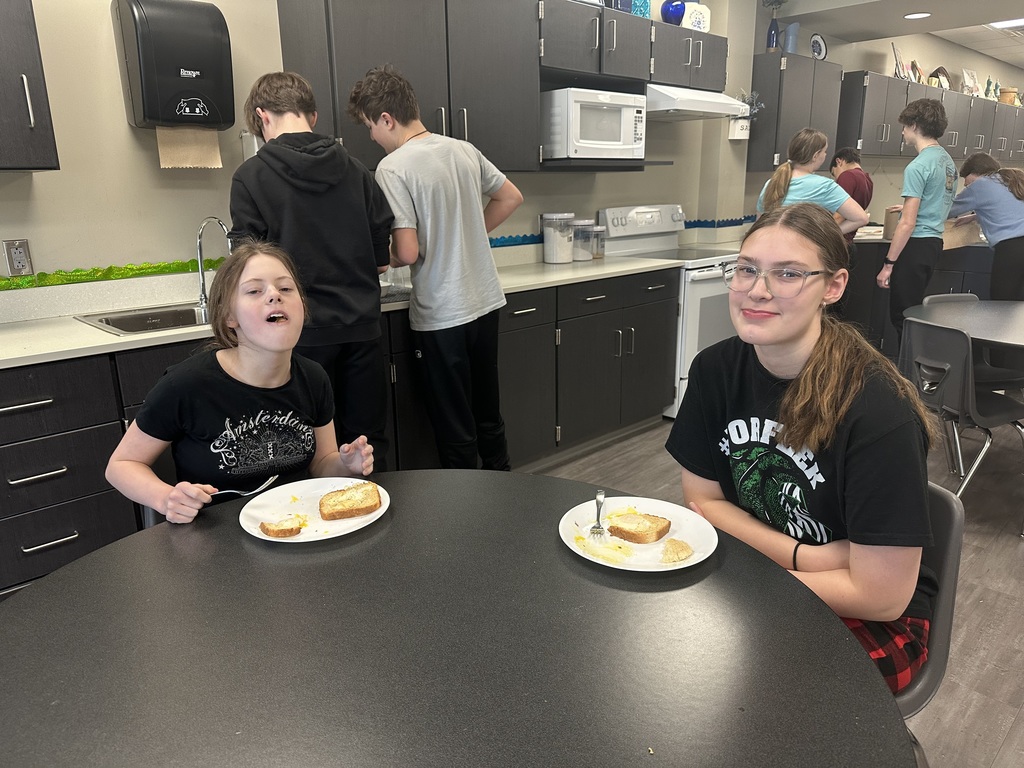 Photo of two students sitting at a table eating.