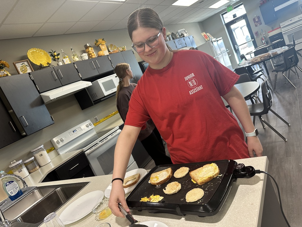Photo of a female student making breakfast on a griddle.