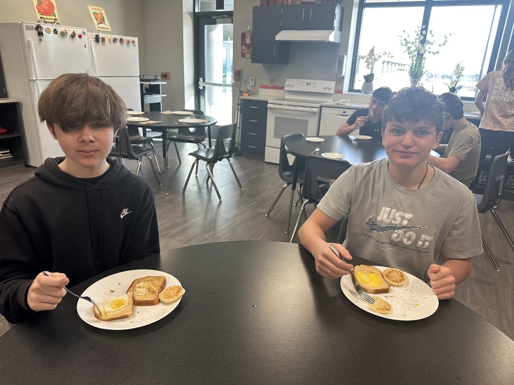Photo of two male students sitting at a table eating their breakfast.
