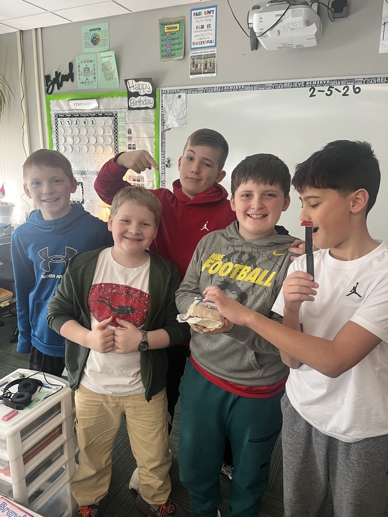 Group of boys standing in front of a classroom smiling