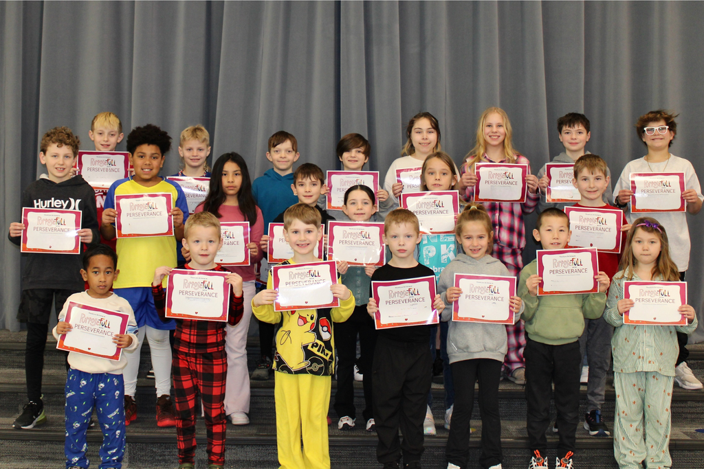 Three rows of students holding their signs for being the Student of the Month who demonstrates Perseverance.