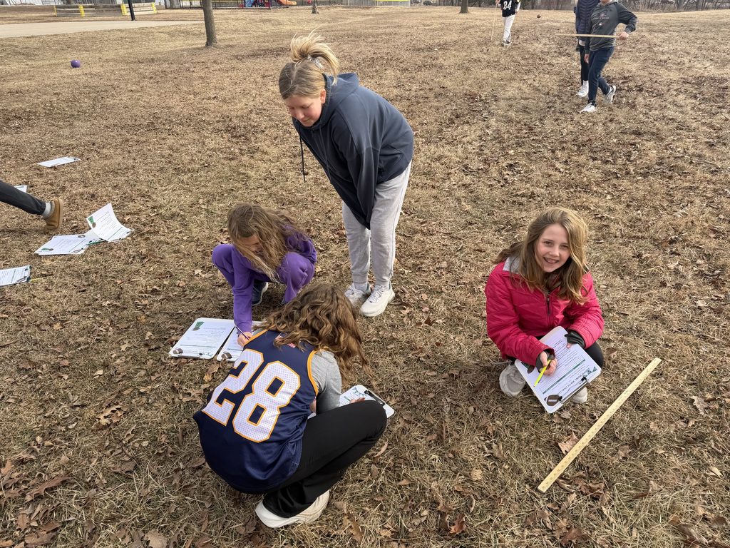 Four girls standing and kneeling outside on a playground