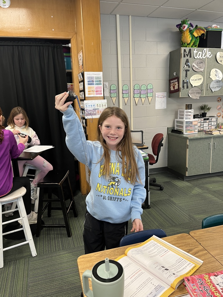 Girl standing holding a magnet with paper clips attached