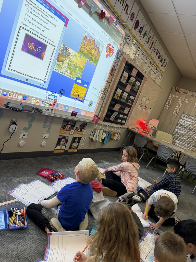 Students working on a social studies unit about America. Sitting on the carpet studying with books.