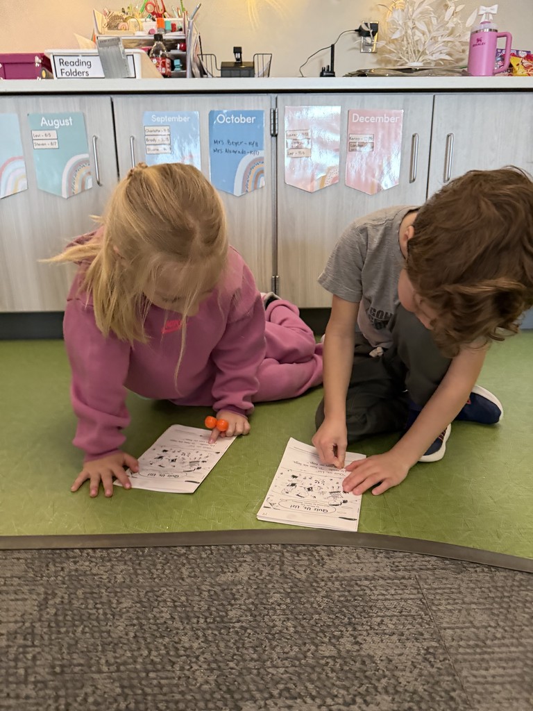 students sitting on the floor reading to one another