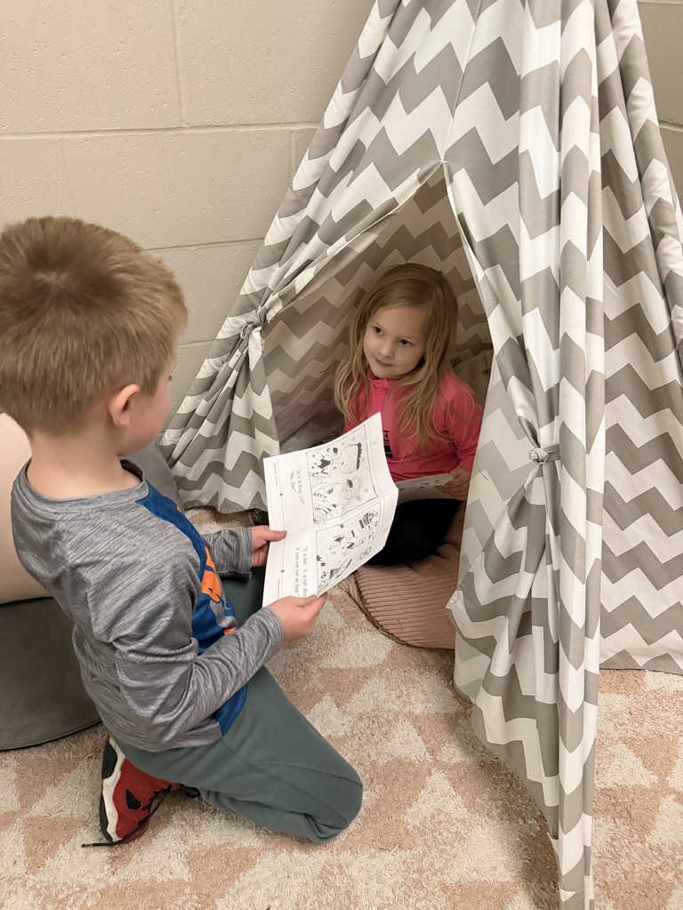 student listening to a story inside a tent