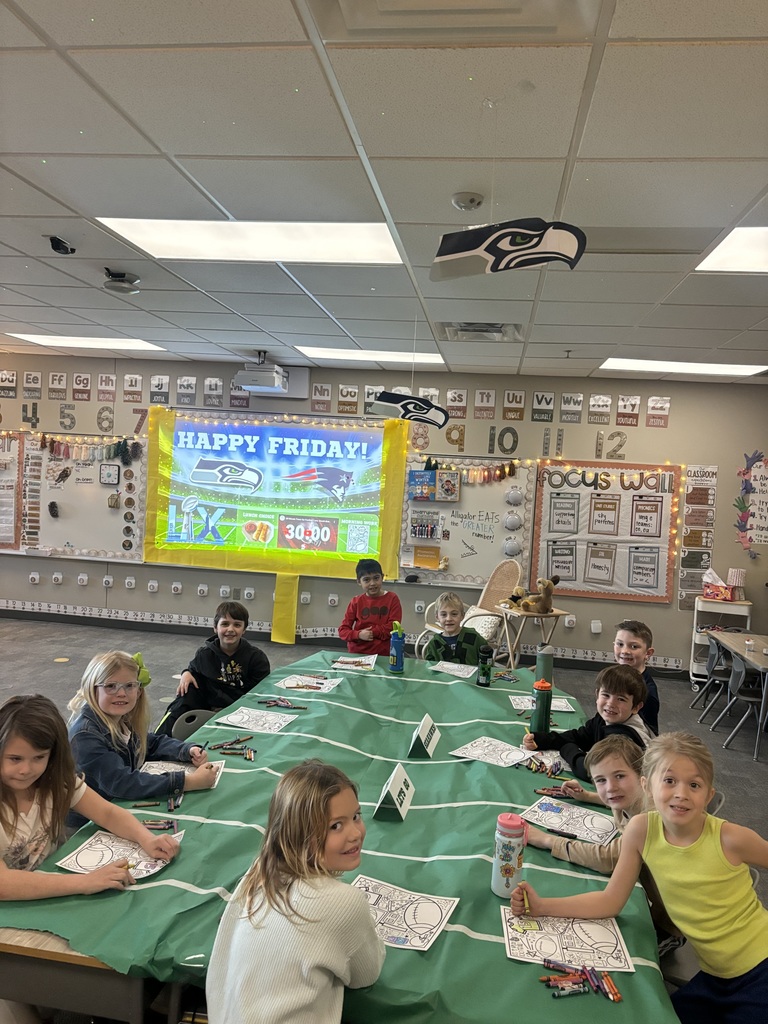 students in first grade smiling at the camera with superbowl themed classroom