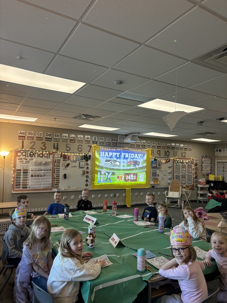 students in first grade smiling at the camera with superbowl themed classroom