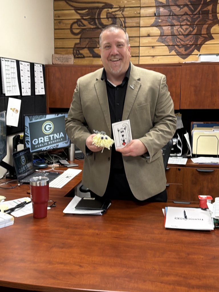 Superintendent Travis Lightle holding his yarn monster and card from Gretna Elementary students.