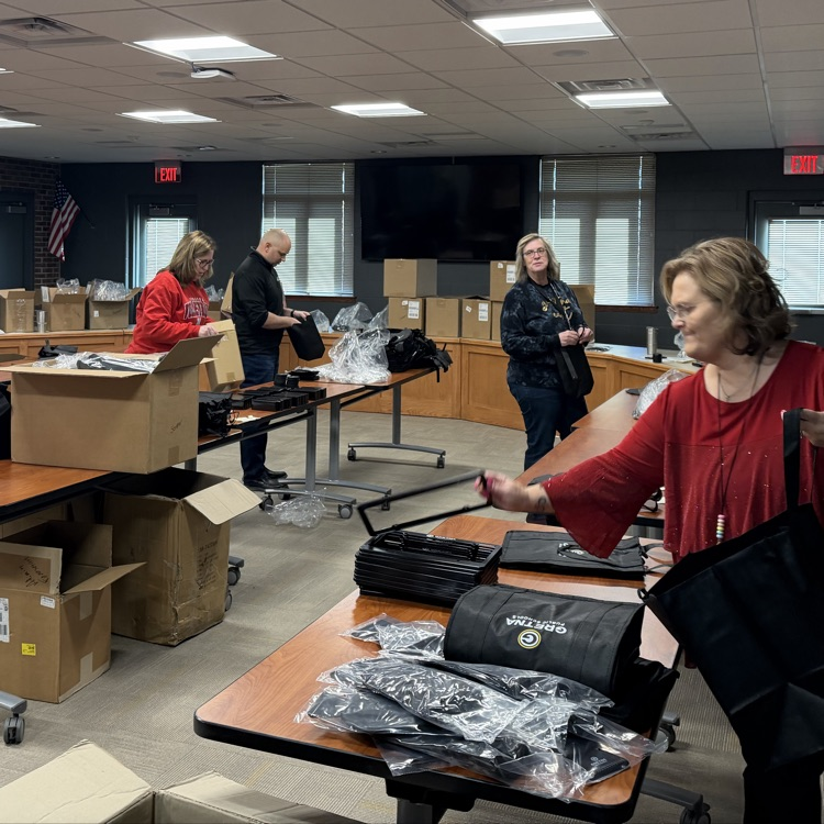 district office board room filled with boxes tables and people filling gifts bags