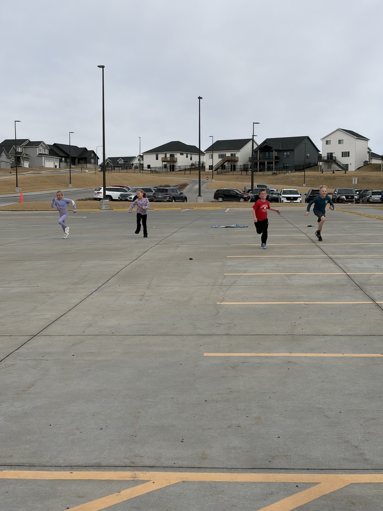 students running a race in a parking lot at school