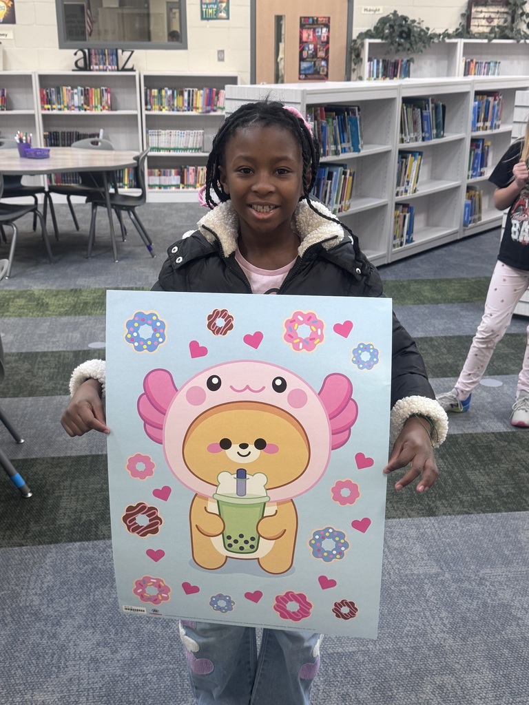 student holding up a poster smiling