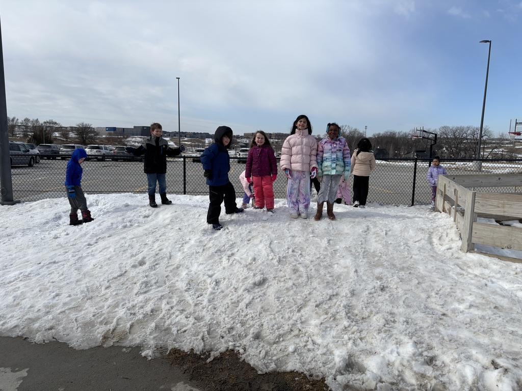 A large group of first graders smile on the snow.