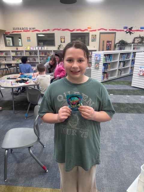 student smiling in the library after winning a trivia question