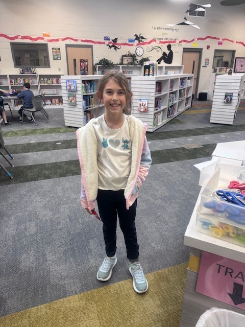 student smiling in the library after winning a trivia question