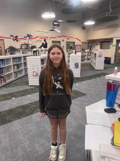 student smiling in the library after winning a trivia question