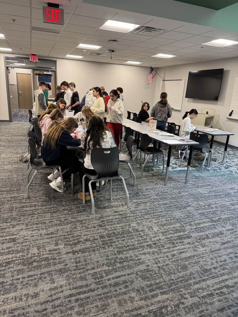 Students are at tables working with Legos and Perler Beads. 