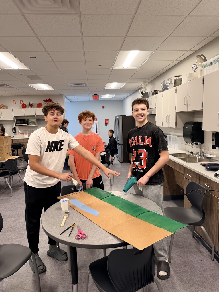 3 boys are painting cardboard. 