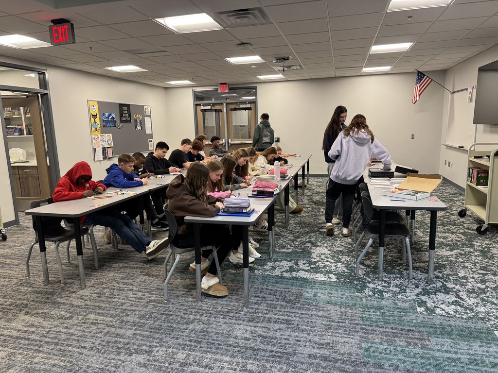 Students are sitting at desks coloring. 