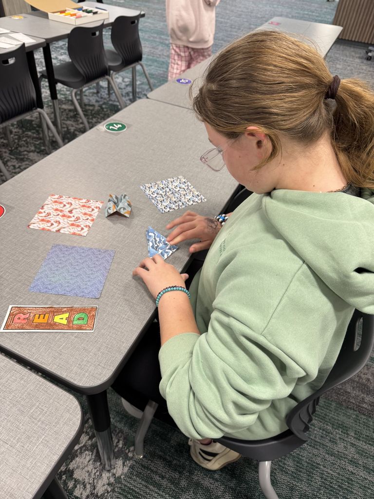 A student is folding origami. 