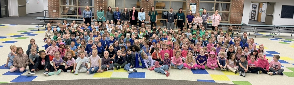 Kindergarten-2nd grade students seated in the cafeteria with Julia Hansen