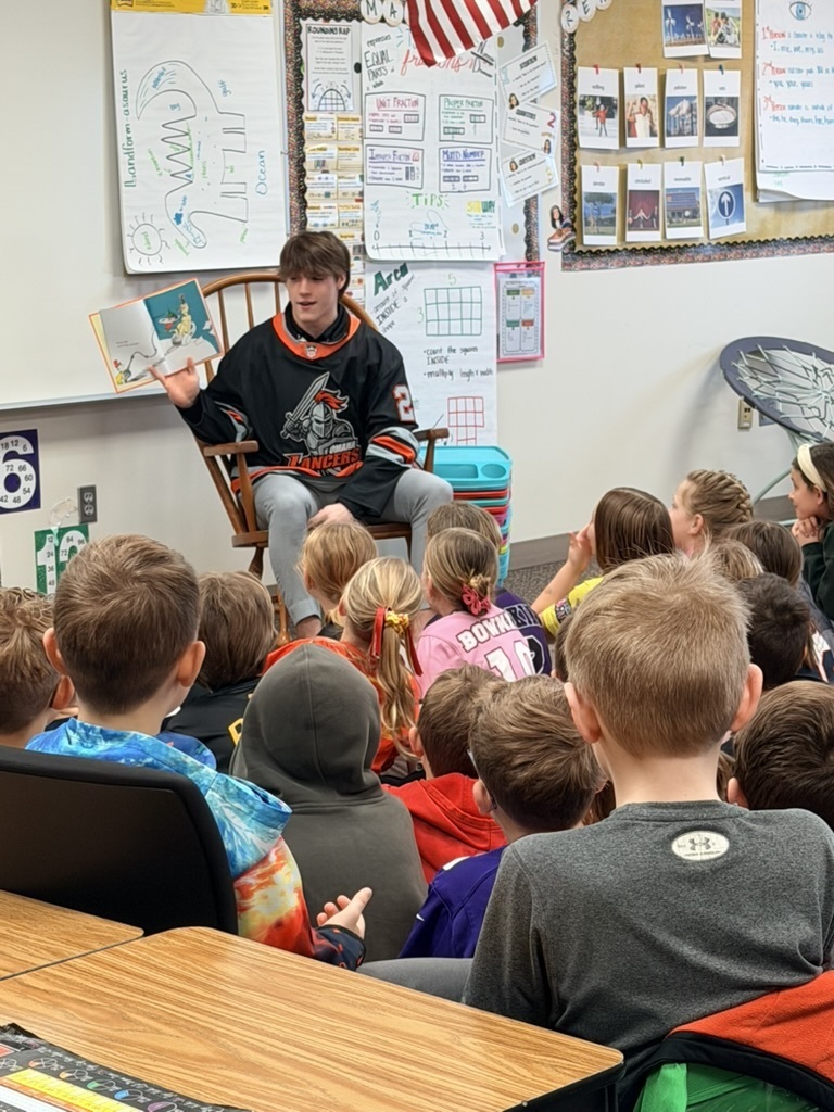 Students seated listening to a member of the Omaha Lancers