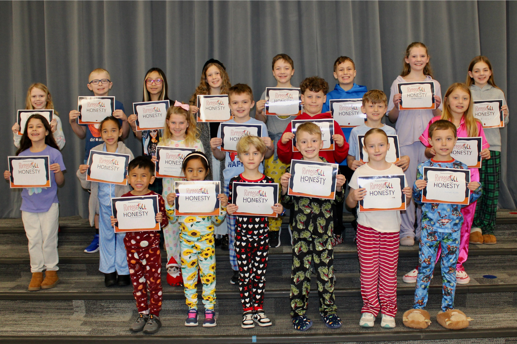 Three rows of students holding their signs for being the Student of the Month who demonstrate Honesty.