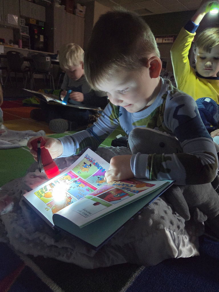 students reading with flashlight