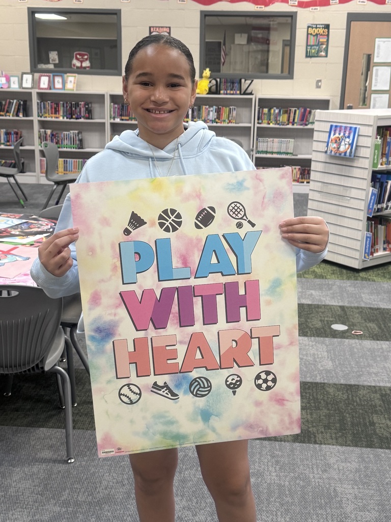 student holding up a poster they won from a book contest