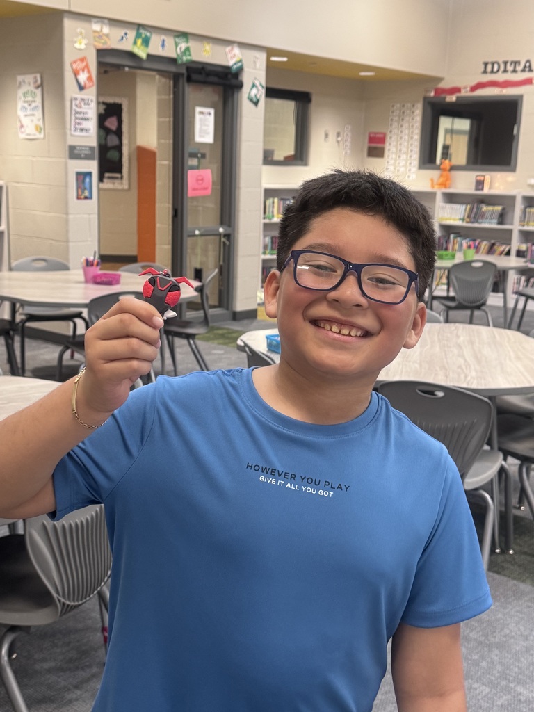 a student smiling with a prize from a book contest