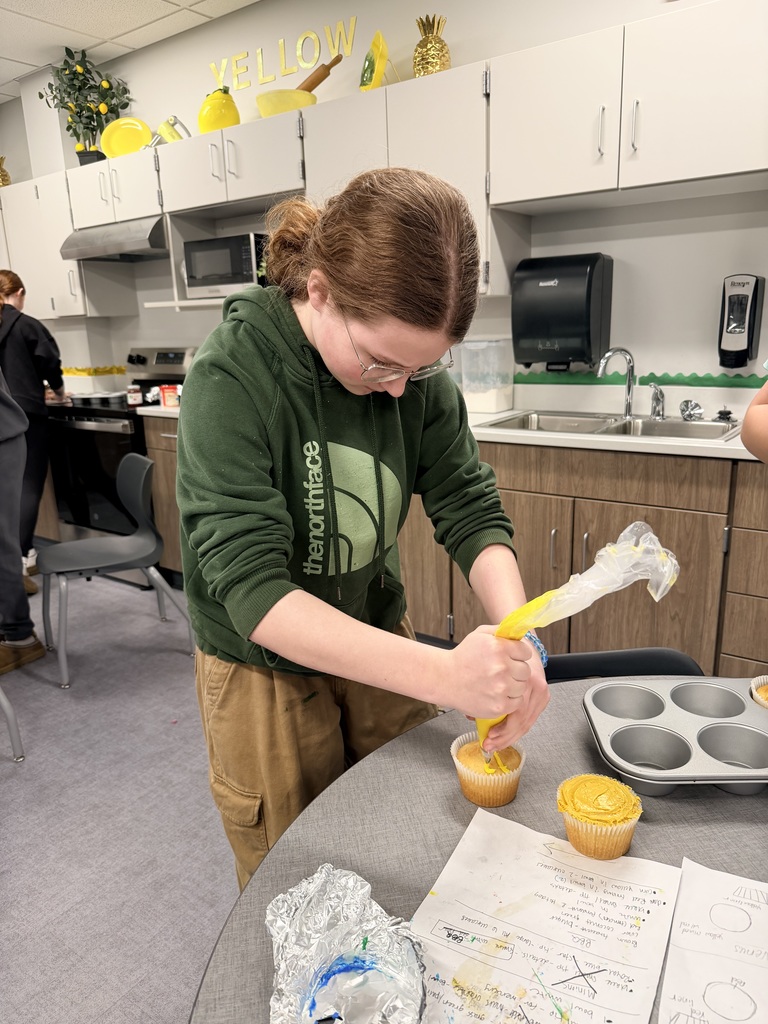 A student is decorating a cupcake. 