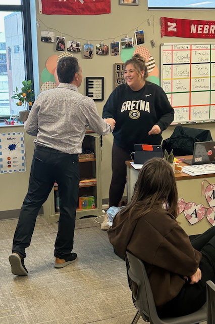 Board Member Rick Hollendieck presenting staff appreciation gift to teacher in classroom with students.