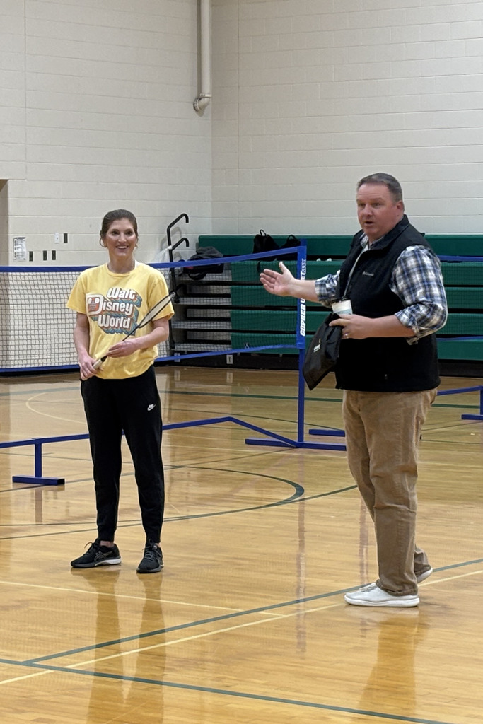 Board member Kyle Janssen presenting staff appreciation gift to teacher in gym
