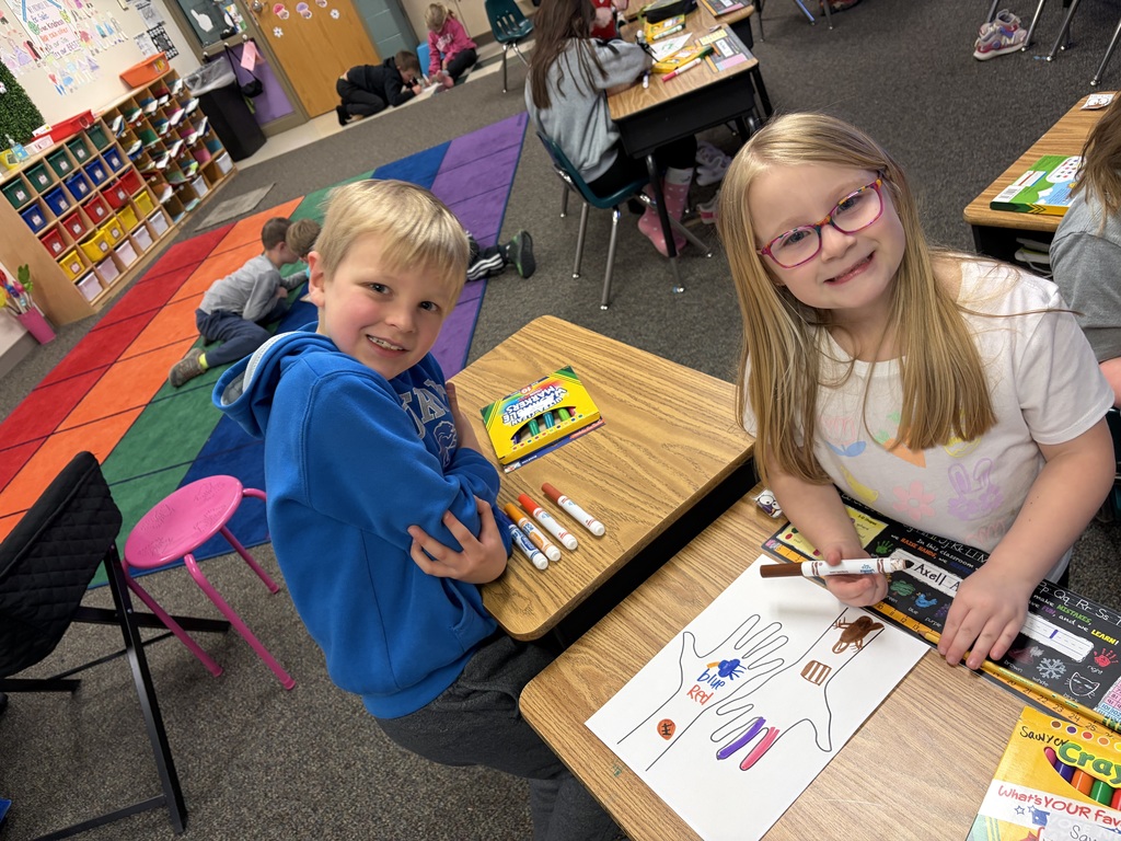 Two students working on a hand project to celebrate their uniqueness.