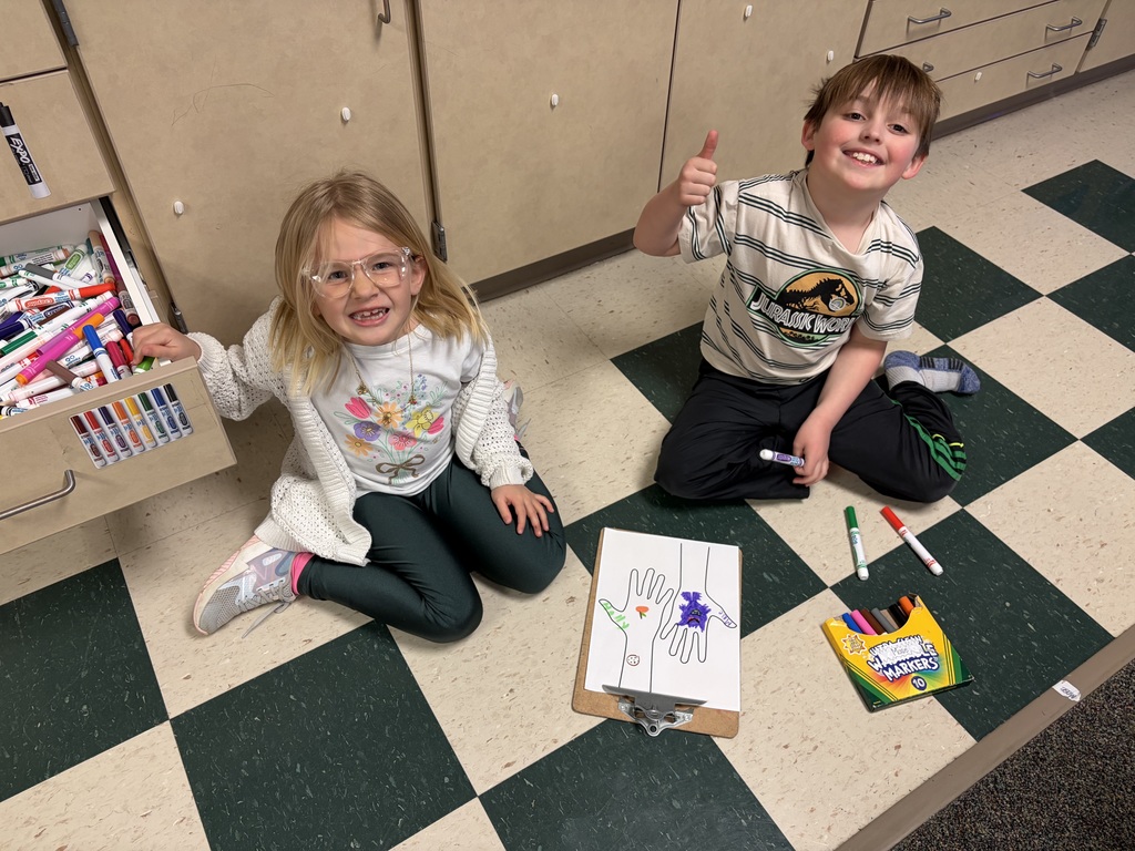 Two students working on a hand project to celebrate their uniqueness.