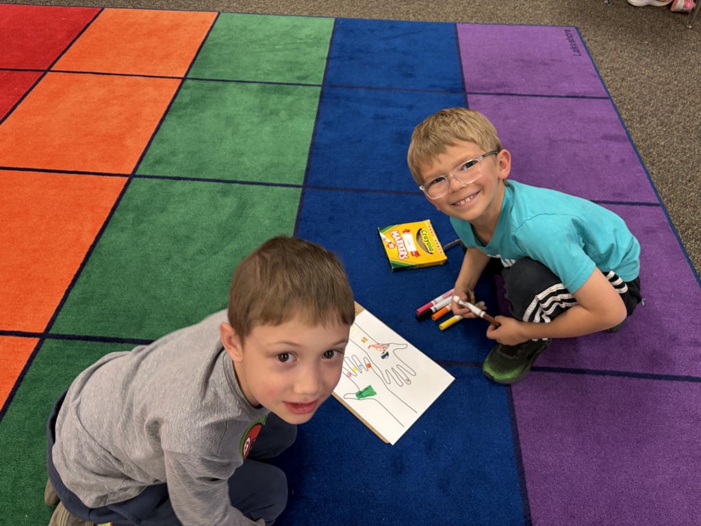 Two students working on a hand project to celebrate their uniqueness.