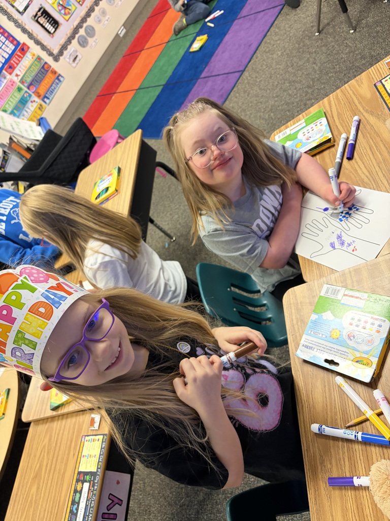 Two students working on a hand project to celebrate their uniqueness.