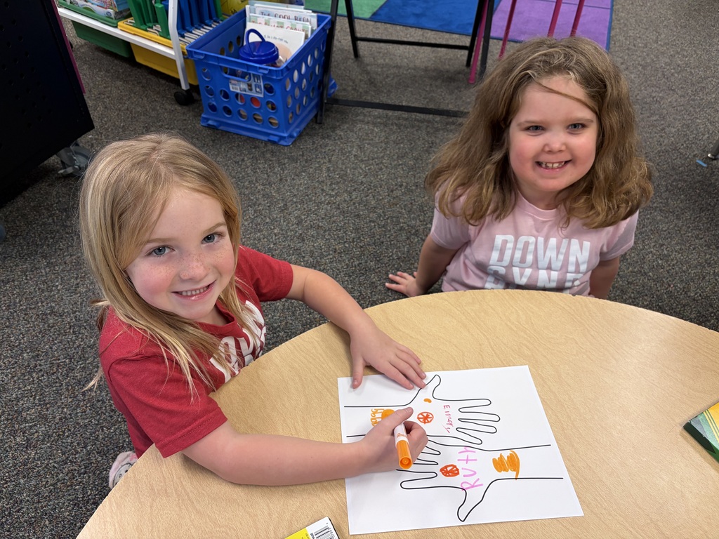 Two students working on a hand project to celebrate their uniqueness.