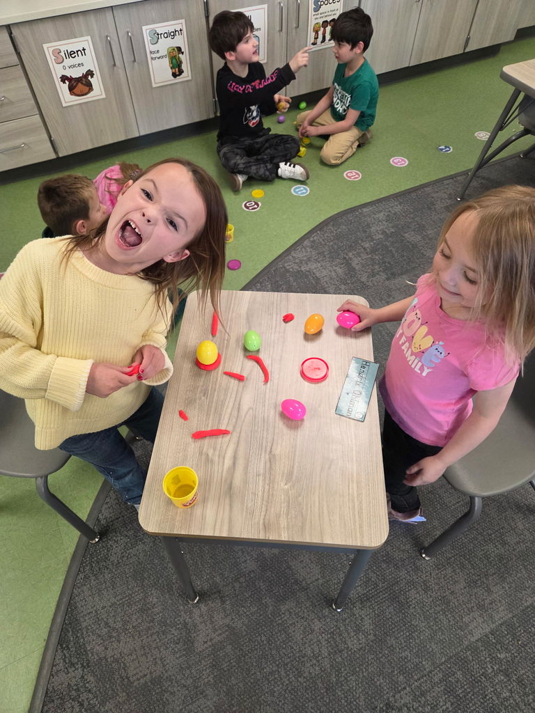 students playing with playdoh and stacking eggs in a classroom for a stem activity.