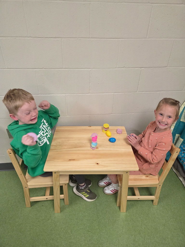 students playing with playdoh and stacking eggs in a classroom for a stem activity.
