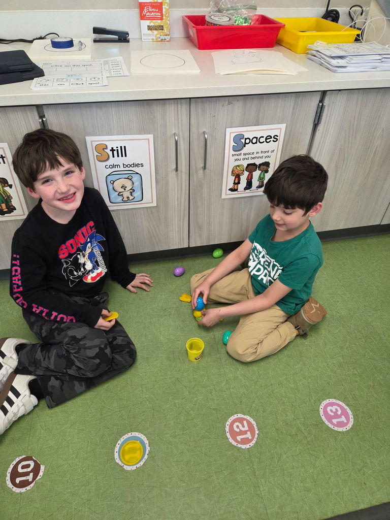 students playing with playdoh and stacking eggs in a classroom for a stem activity.