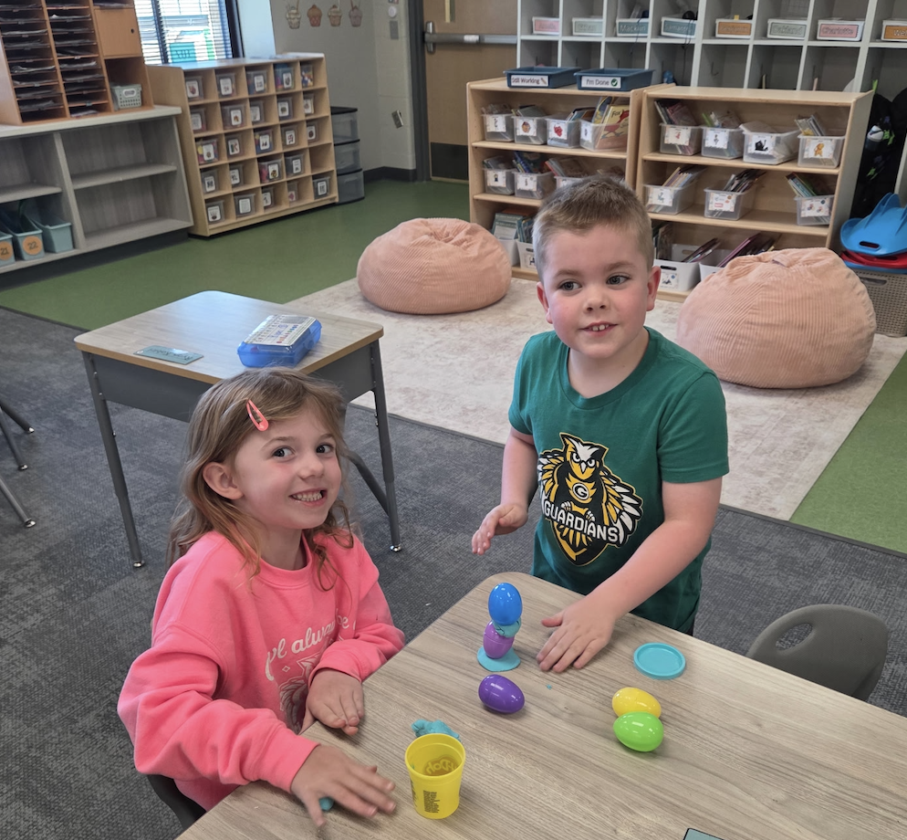 students playing with playdoh and stacking eggs in a classroom for a stem activity.