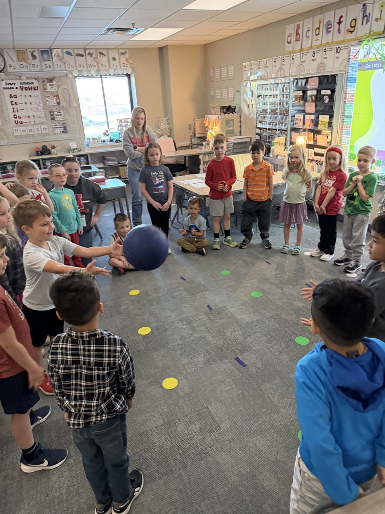 students in a circle playing a game with a ball