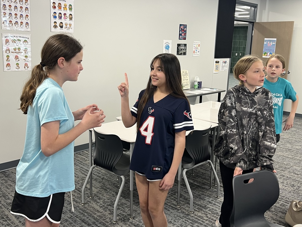 Four students practice signing with each other.