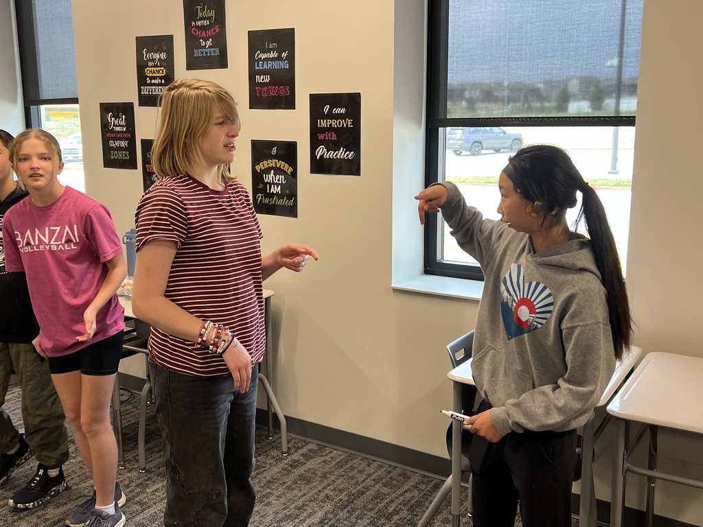 Two students practice signing with each other.