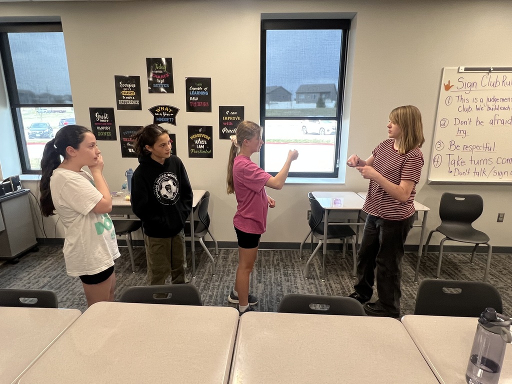 Four students practice signing with each other.