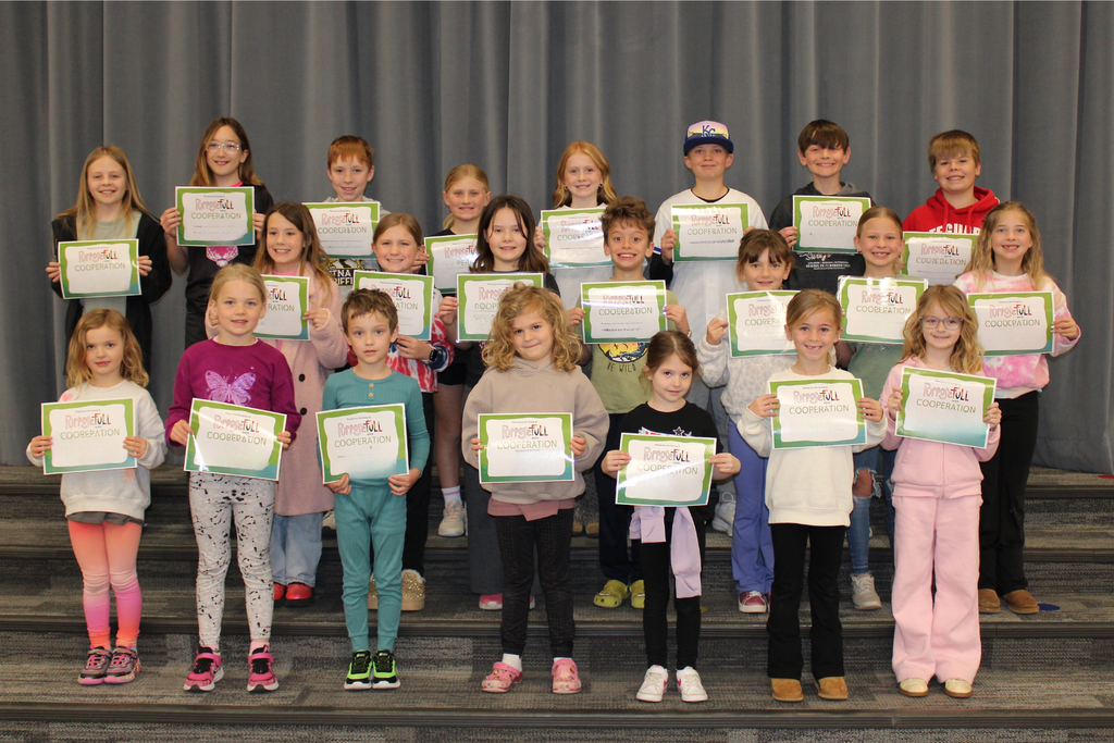 Three rows of students holding their signs for being the Student of the Month who demonstrate Cooperation.